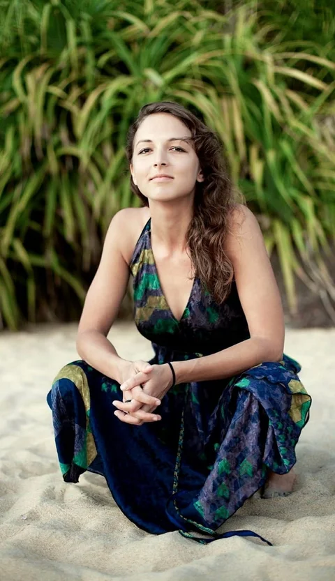 Gorana Bajčetić, founder of Green Yogi Traveler, sitting on the beach