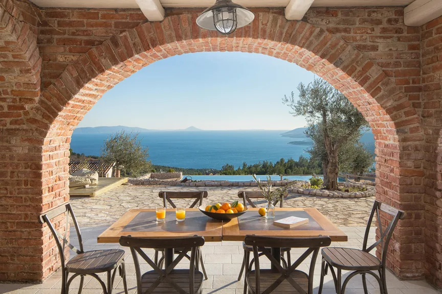 Brick arch terrace with a dining table and the Adriatic view at the villa in Rabac, Boutique Guitar Retreat in Croatia with Henry Olsen
