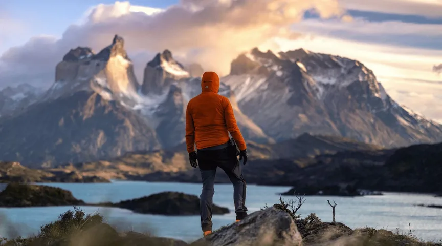 Hiker overlooking glacial lake and Patagonian mountains, Argentina retreat