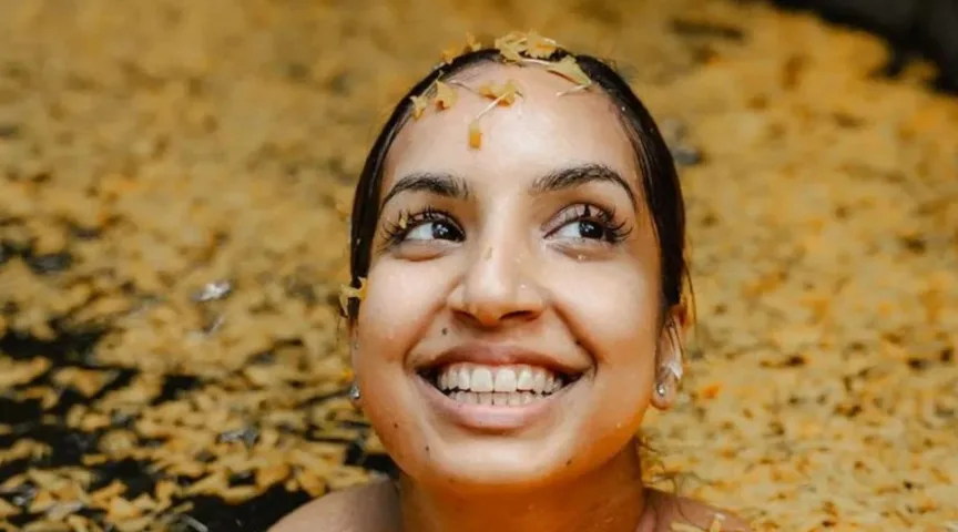 Smiling woman in a traditional flower bath ritual — Wild Souls retreat Thailand