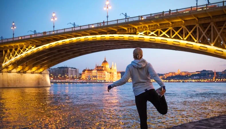 Yoga stretch overlooking the Danube and Parliament building at dusk, Budapest