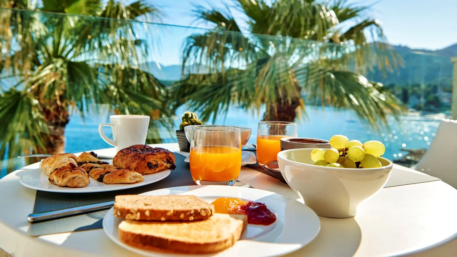Breakfast terrace framed by palm trees overlooking the sea at Hilton Lopud Beach Resort, Croatia