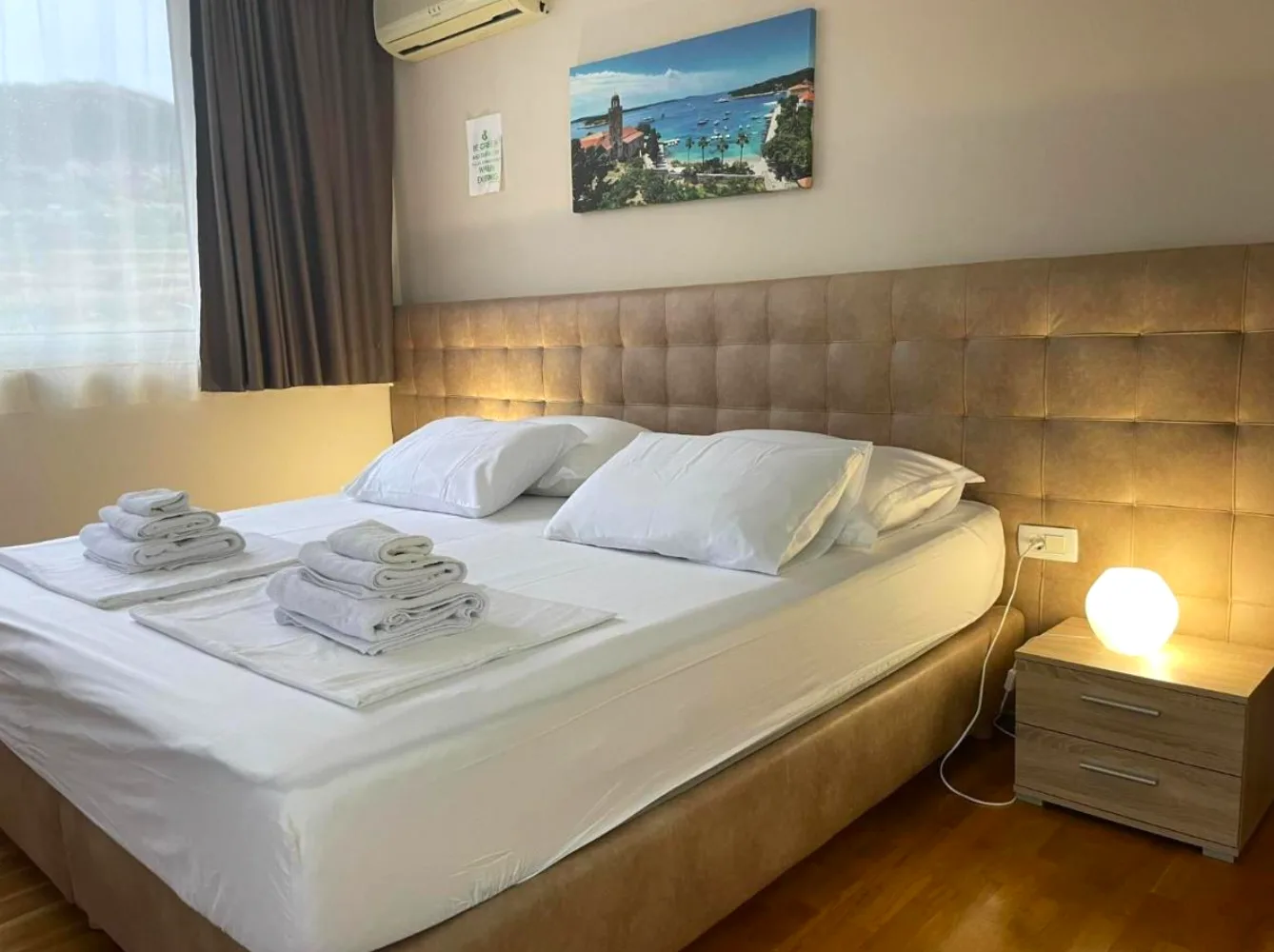 Double room with tufted headboard and sea-view window at B&B Dela, Hvar Town, Croatia
