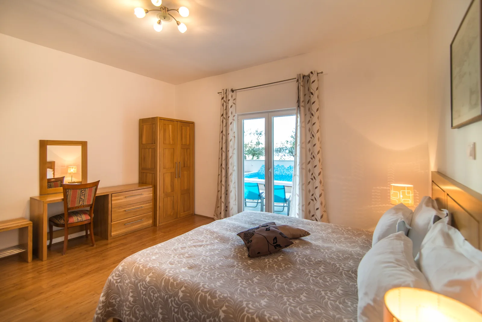 Ground-floor bedroom with French doors onto the pool terrace at Villa Mirca, Brač Island