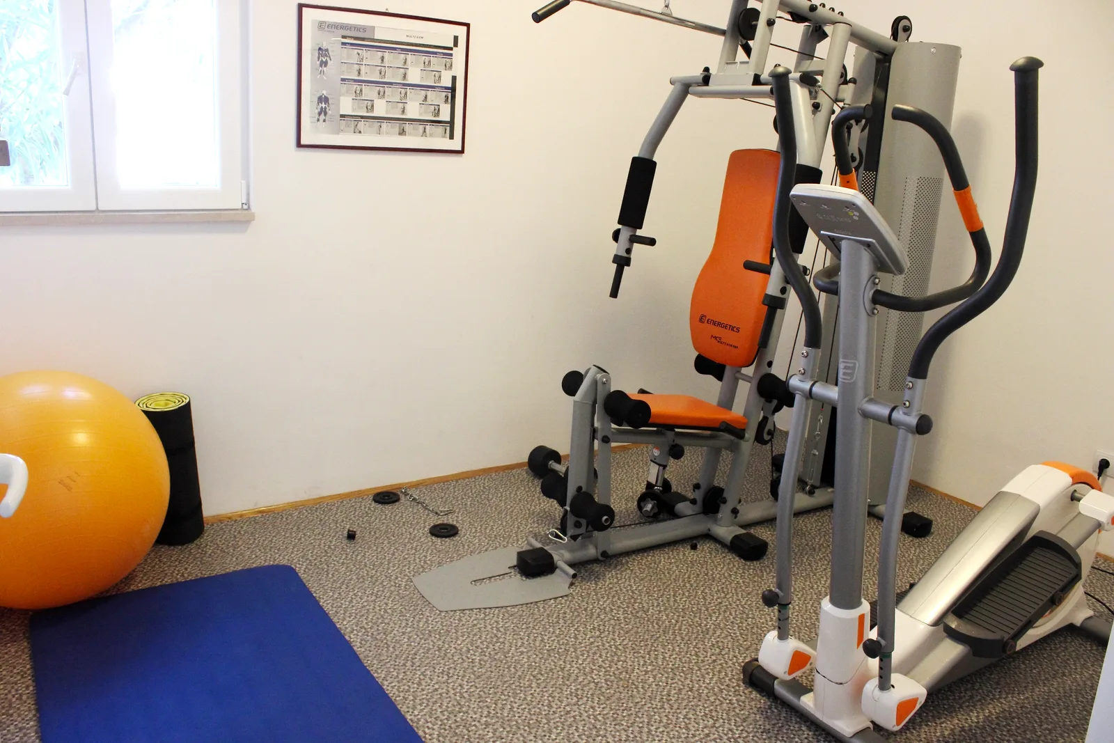 Indoor fitness room with a multi-gym, cross trainer and exercise mats at Villa Mirca, Brač Island