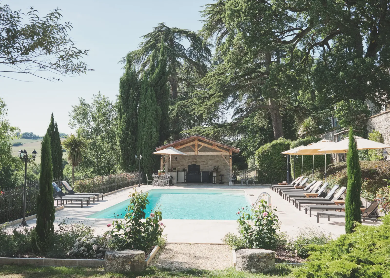 Heated swimming pool with sun loungers and pool house at Château de Lassalle, France