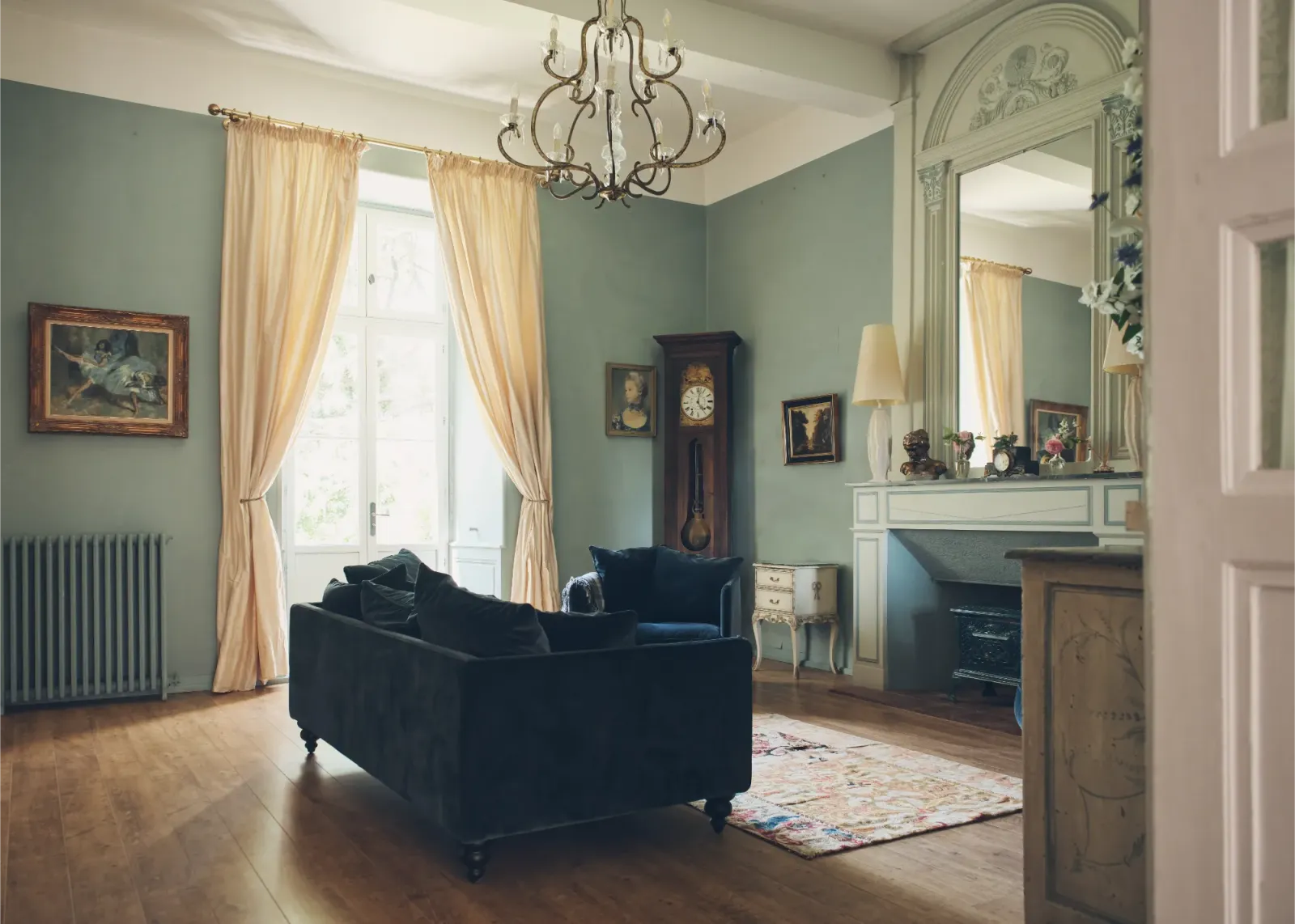 Formal sitting room with chandelier and fireplace at Château de Lassalle, France