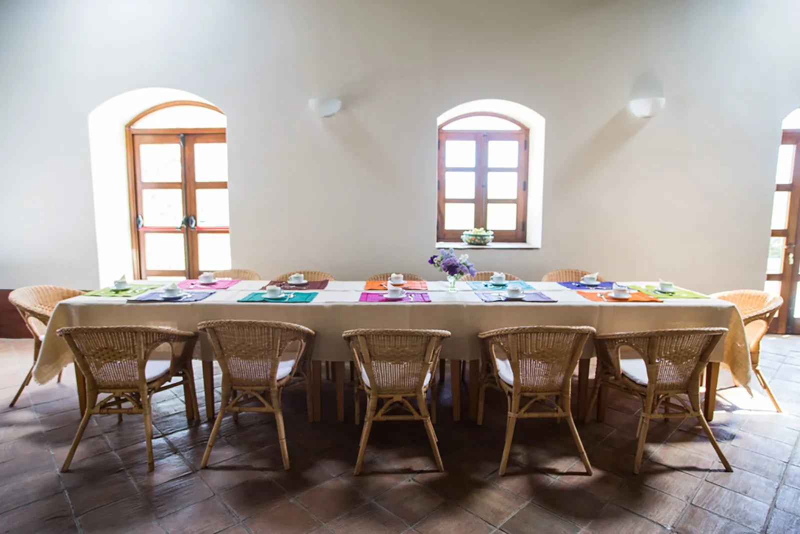Dining room with a long table set with colorful placemats at Sicilian Spirit, Sicily