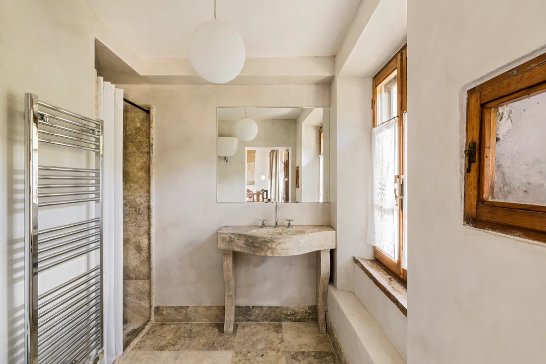 Bathroom with stone sink and heated towel rail at Ebbio Tuscany, Italy