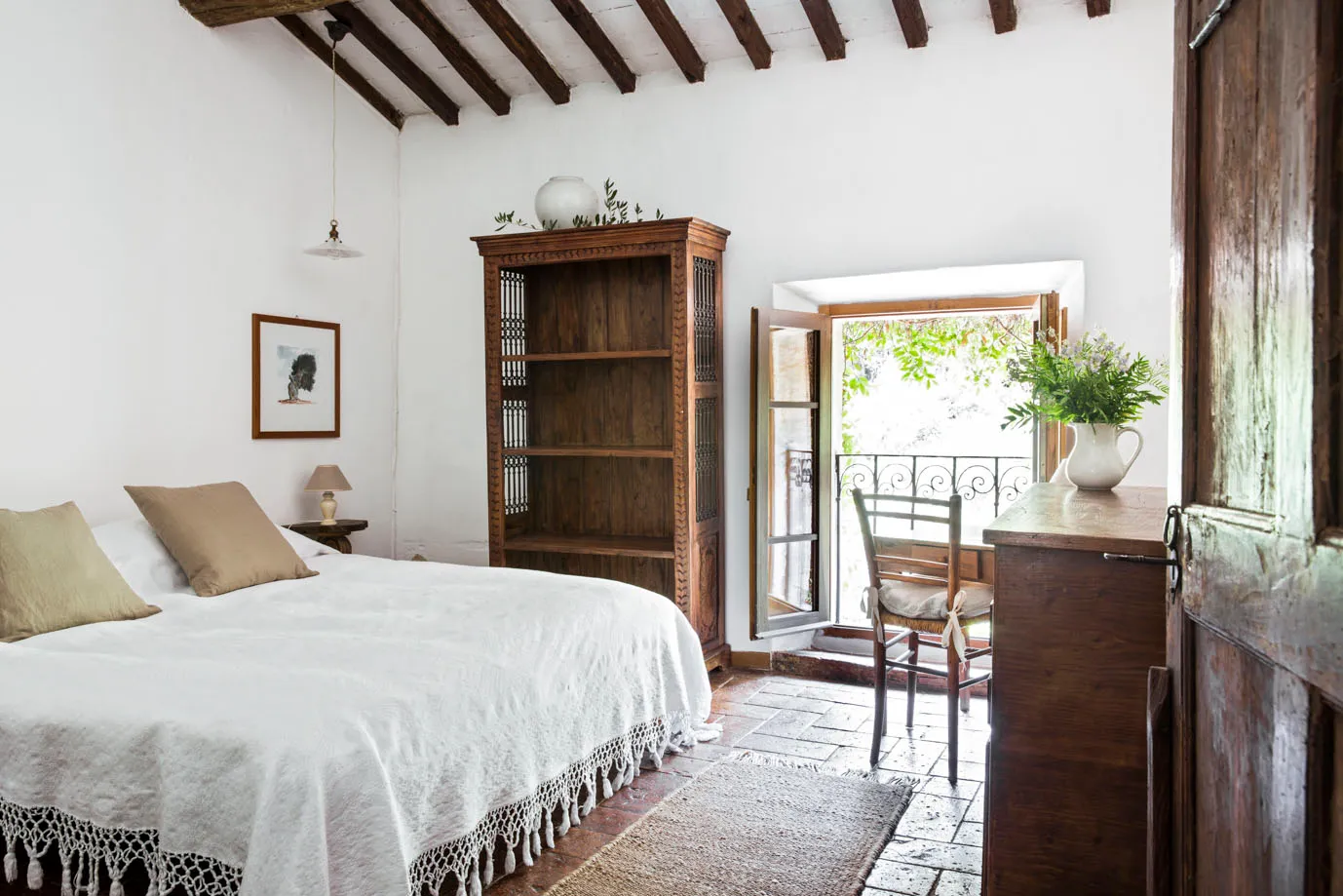 Bedroom with white bedspread and balcony door at Ebbio Tuscany, Italy