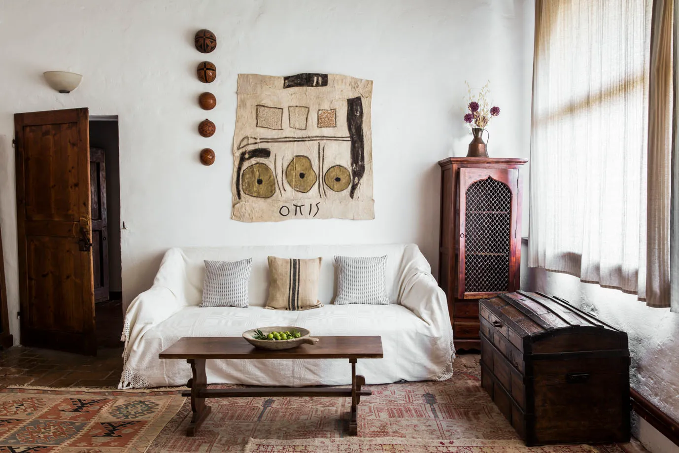 Common room with white sofa, chest and rugs at Ebbio Tuscany, Italy