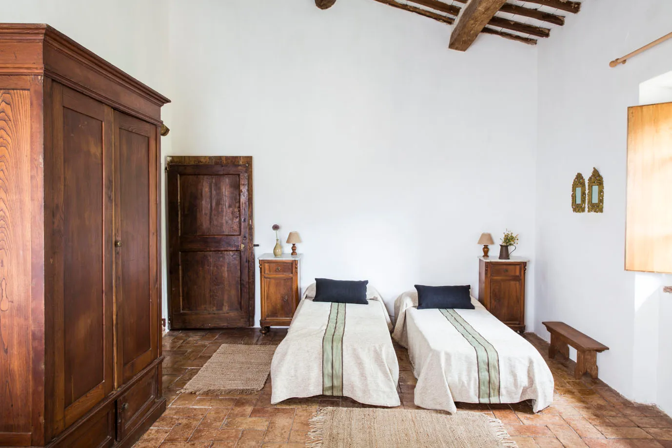 Bedroom with two single beds and a wooden wardrobe at Ebbio Tuscany, Italy