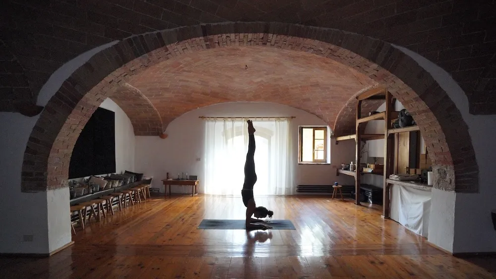 Yoga practice in a brick-vaulted room at Ebbio Tuscany, Italy