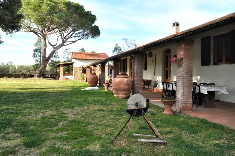 Farmhouse terrace with terracotta amphorae and an old olive press at Il Risveglio, Tuscany