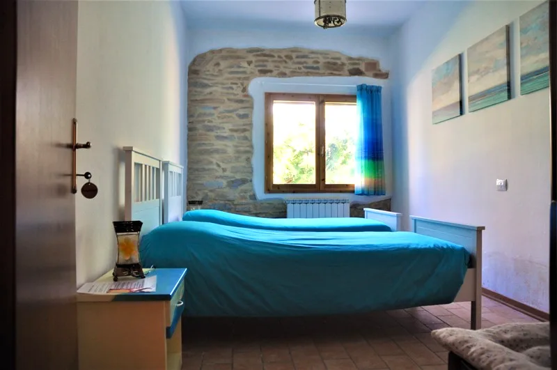 Fiordaliso twin room with a stone wall accent at Il Risveglio, Tuscany