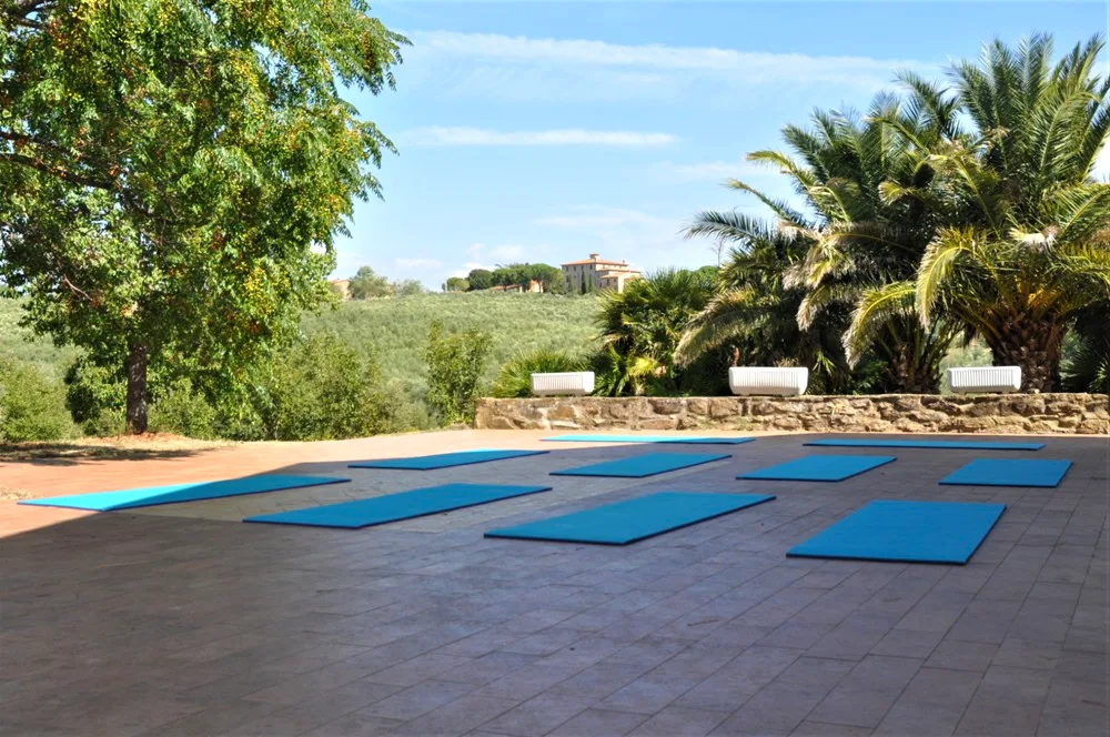 Yoga mats laid out on the outdoor terrace overlooking the Tuscan hills at Il Risveglio