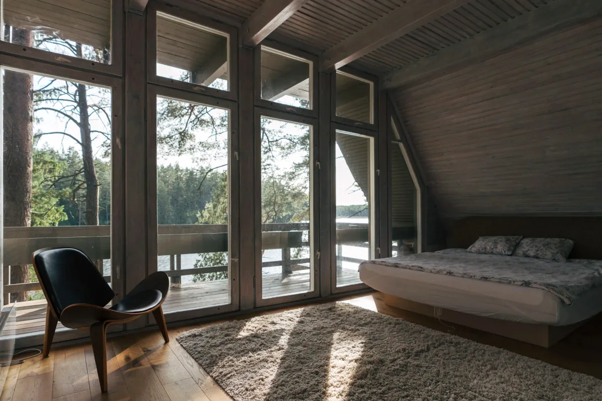 Bedroom with panoramic forest-facing windows in Big House at Šiaurys Resort, Lithuania
