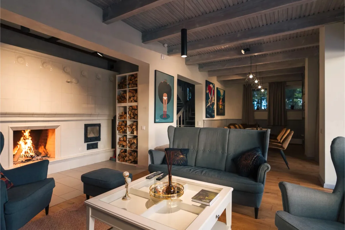 Living room with a tiled fireplace in Big House at Šiaurys Resort, Lithuania