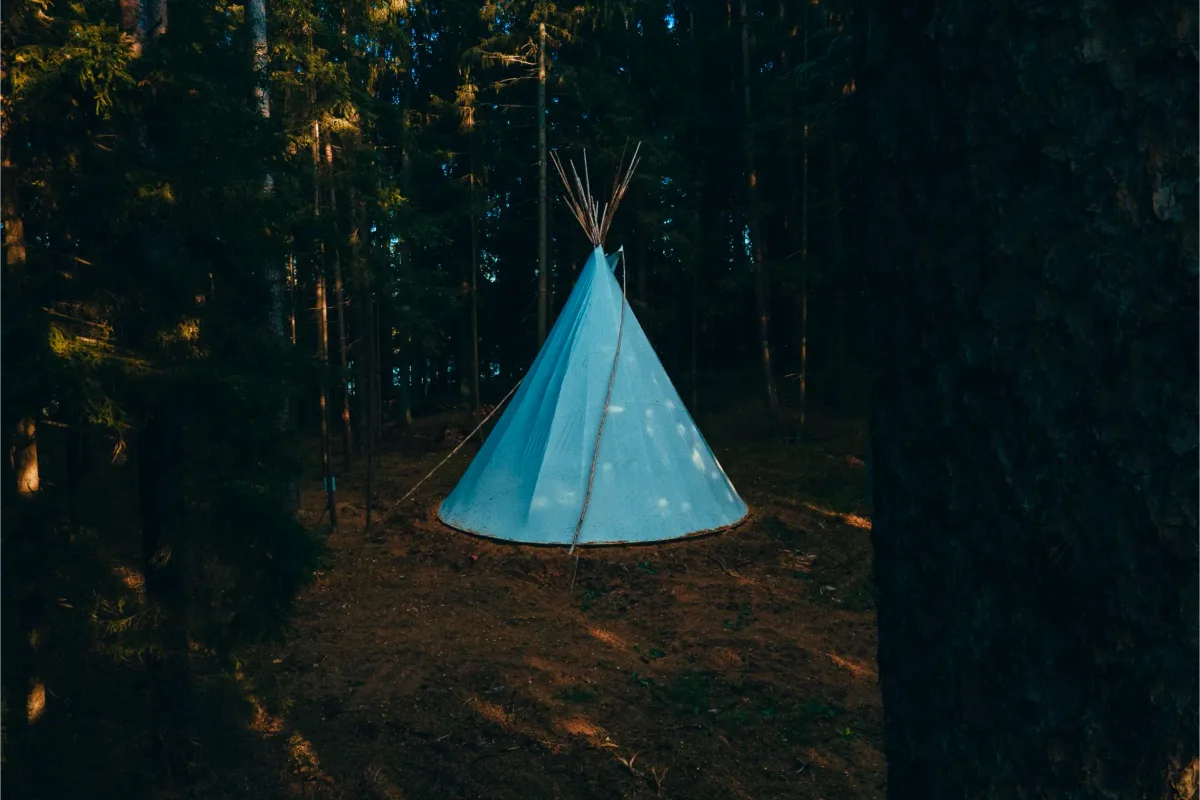 Canvas tipi set among the pines for ceremony and workshops at Šiaurys Resort, Lithuania