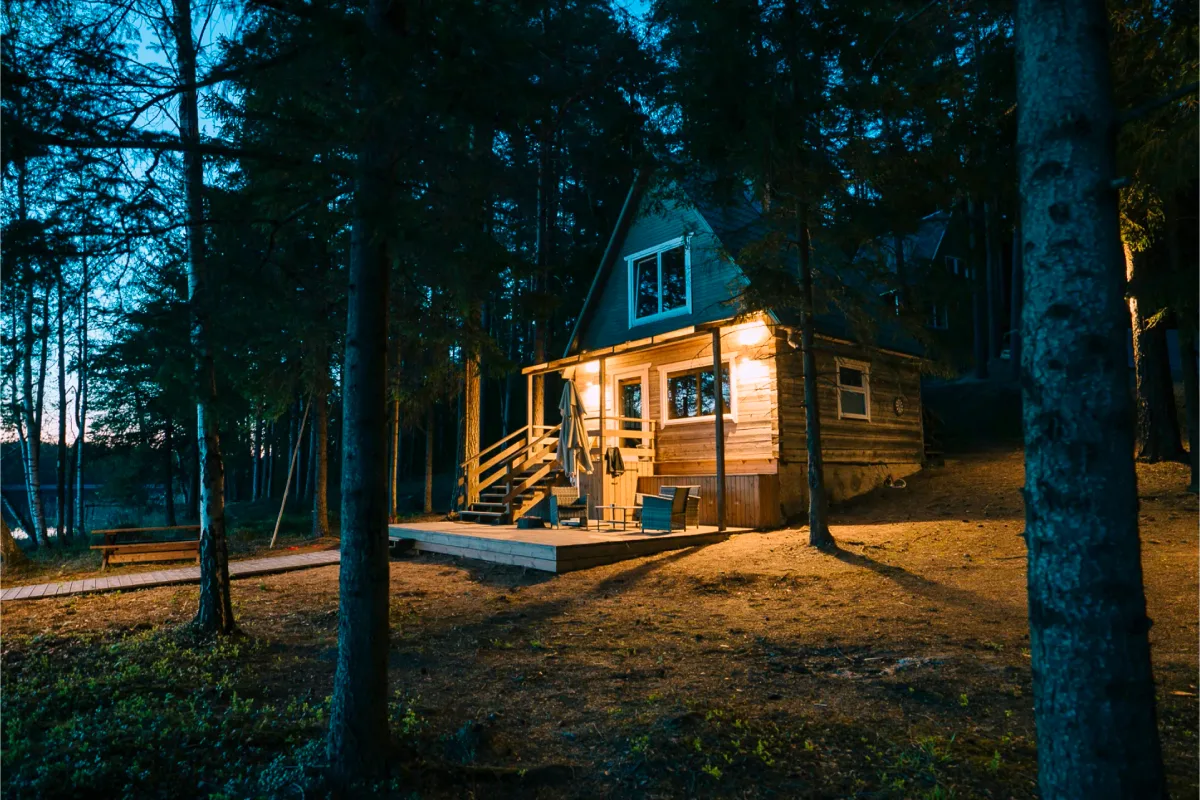 The ritual sauna house lit up at twilight by the lake at Šiaurys Resort, Lithuania