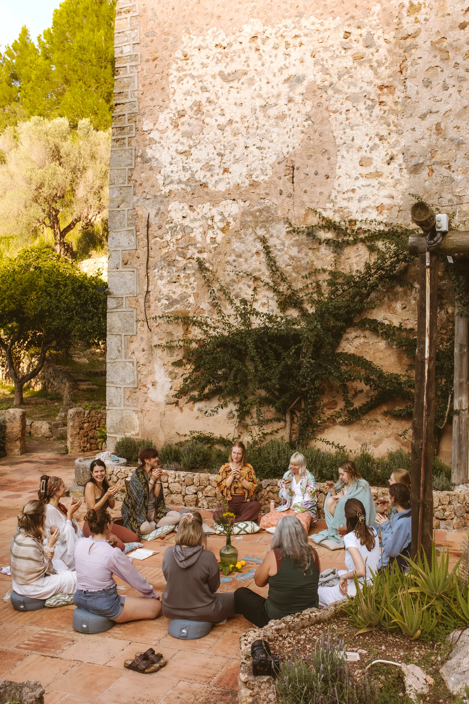 Two retreat guests in a heart-hands closing ritual on the steps at Finca Higo, Mallorca
