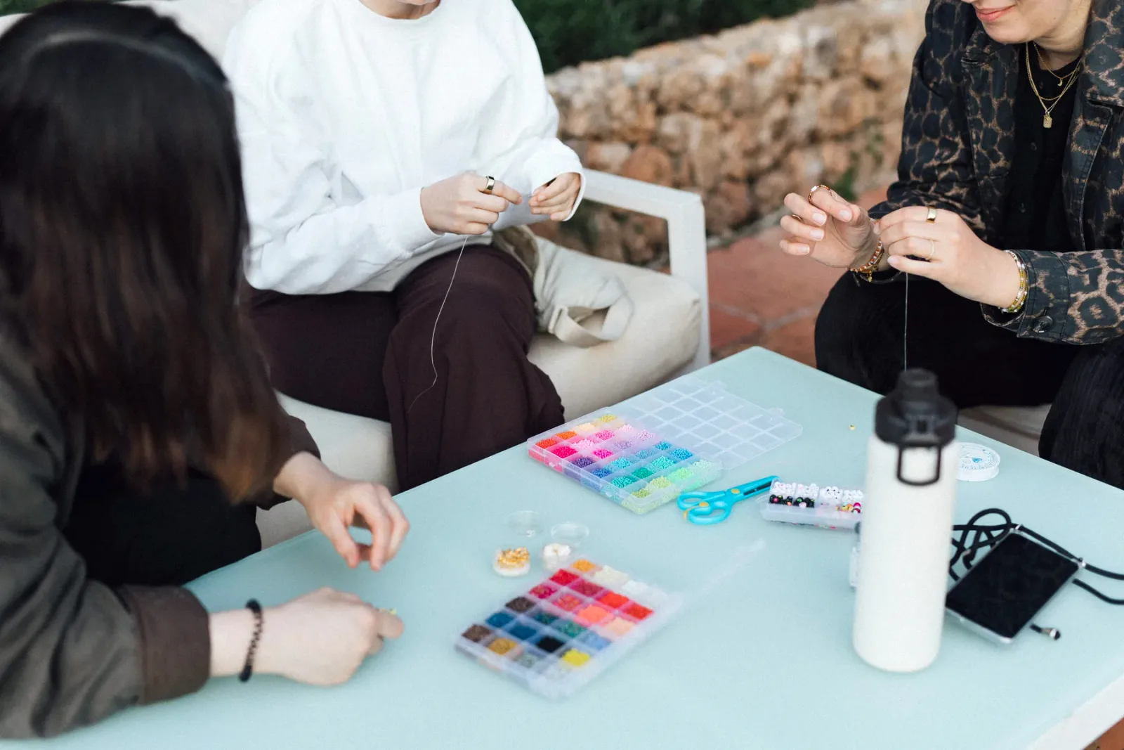 Retreat guests making bracelets together at the table, Mallorca