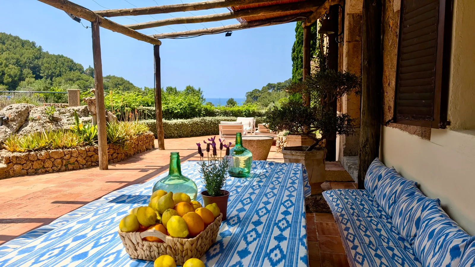 Terrace dining table with citrus trees and sea view at Finca Higo, Mallorca