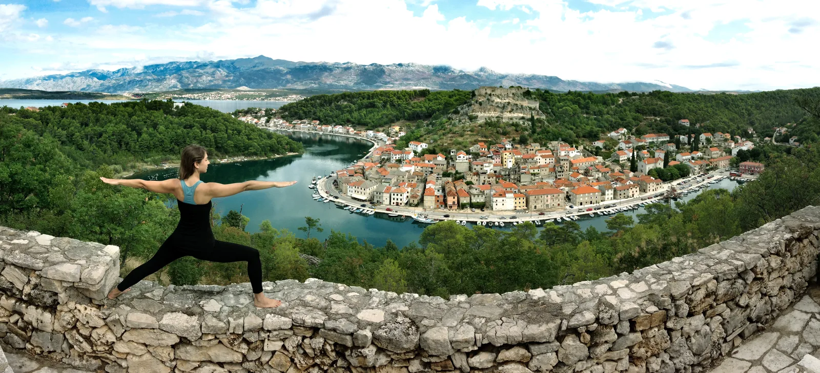 Warrior II pose on a stone wall above Novigrad and the Adriatic, Croatia — Adventure Croatia retreat