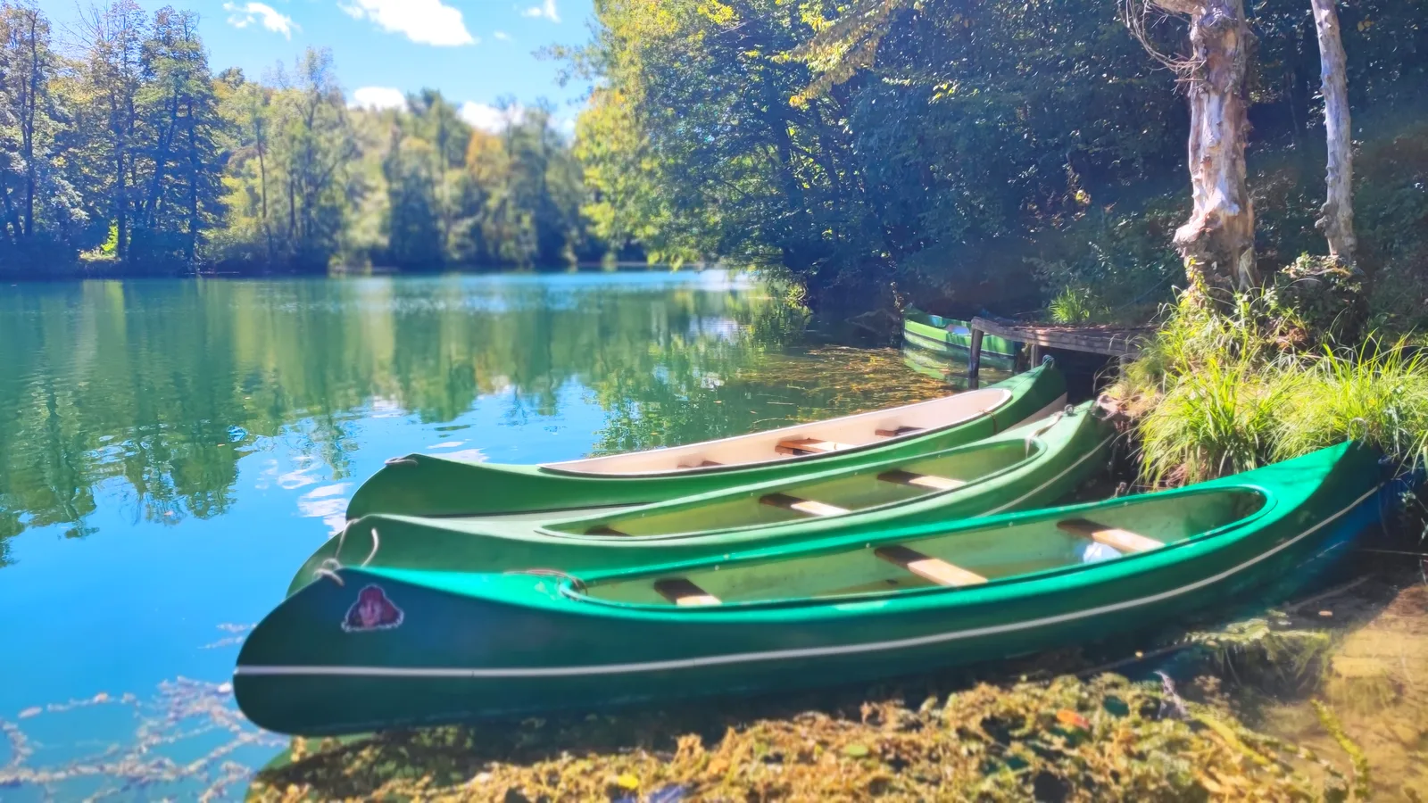Green canoes on the turquoise Mrežnica river, Croatia