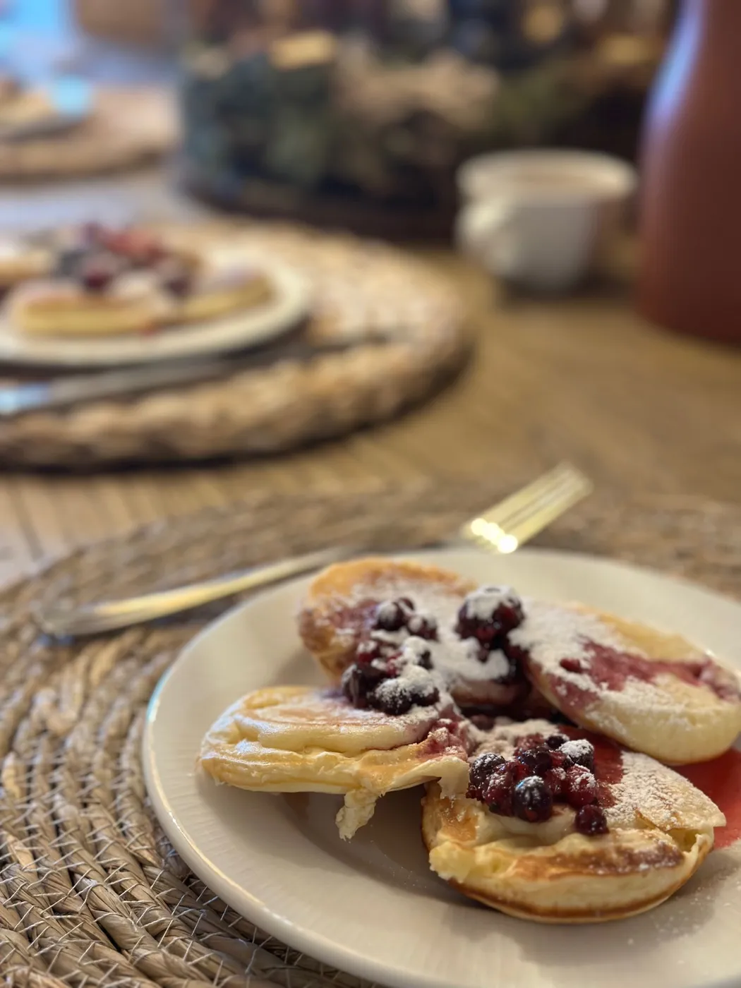 Pancakes topped with berries on a woven placemat, served at Terra Belá