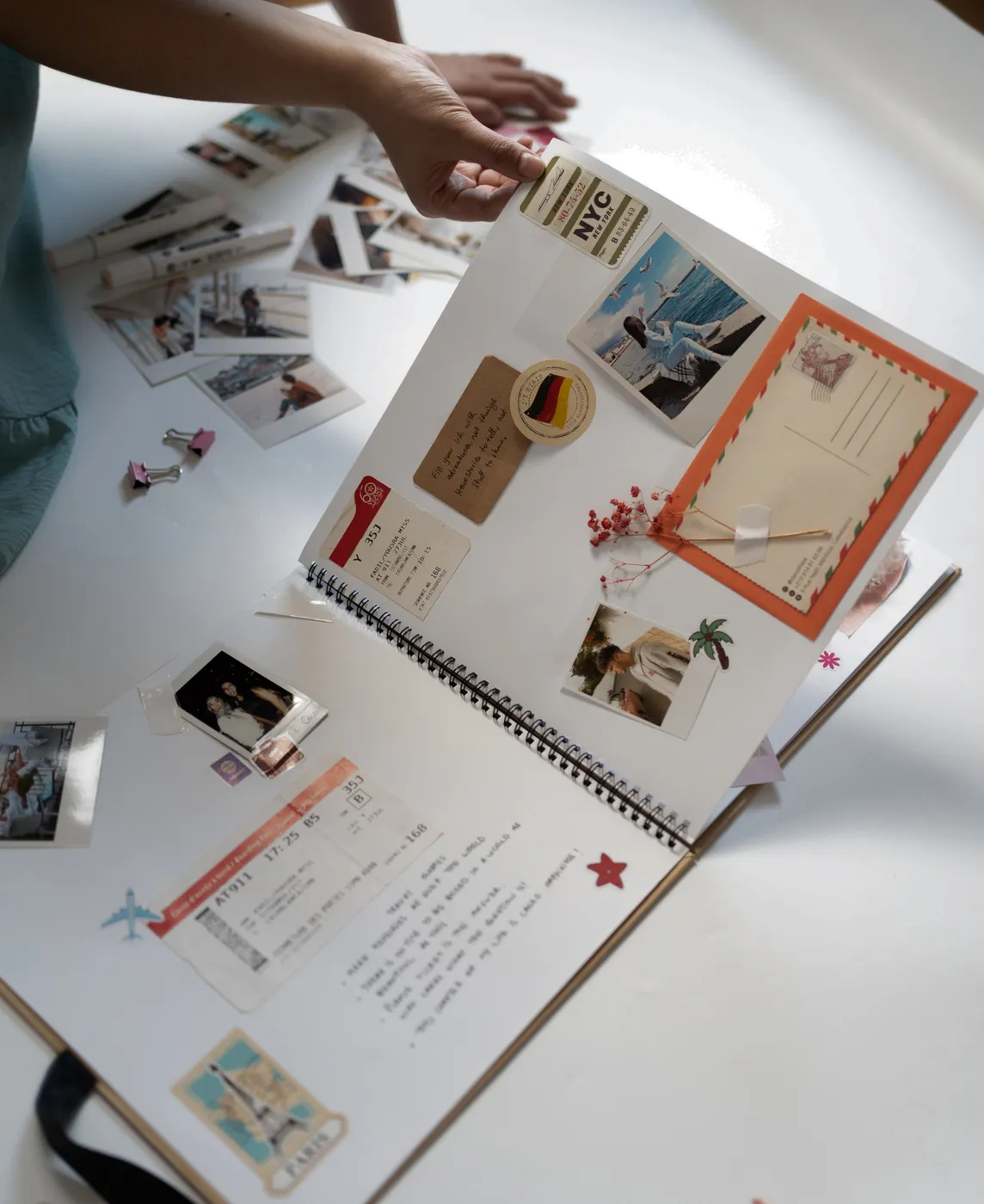 Open vision board notebook with photos and postcards from the Vision Board workshop