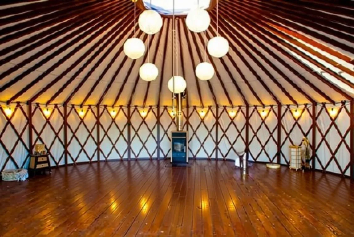Inside the yoga yurt at Terra Belá with a wooden floor and warm lanterns